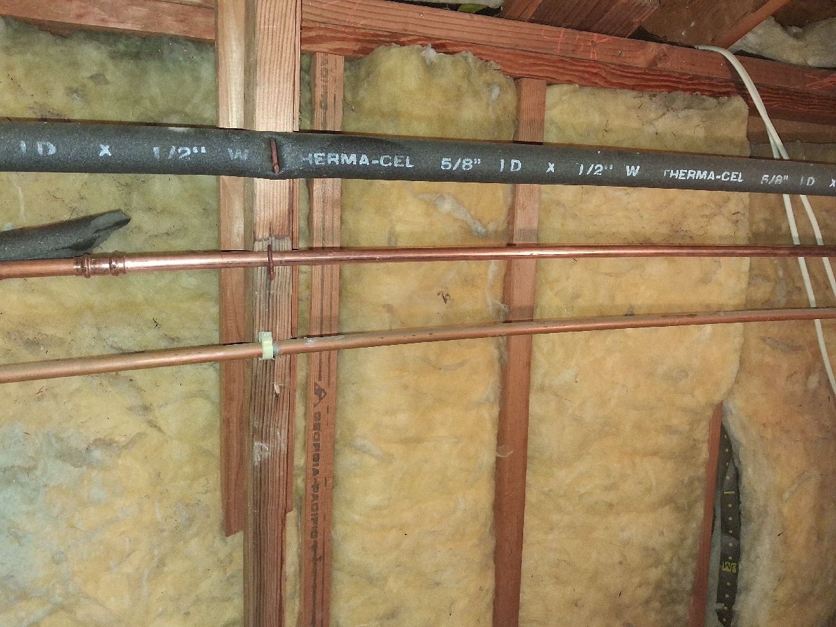 New copper pipe section with a press connection exposed inside a wall cavity